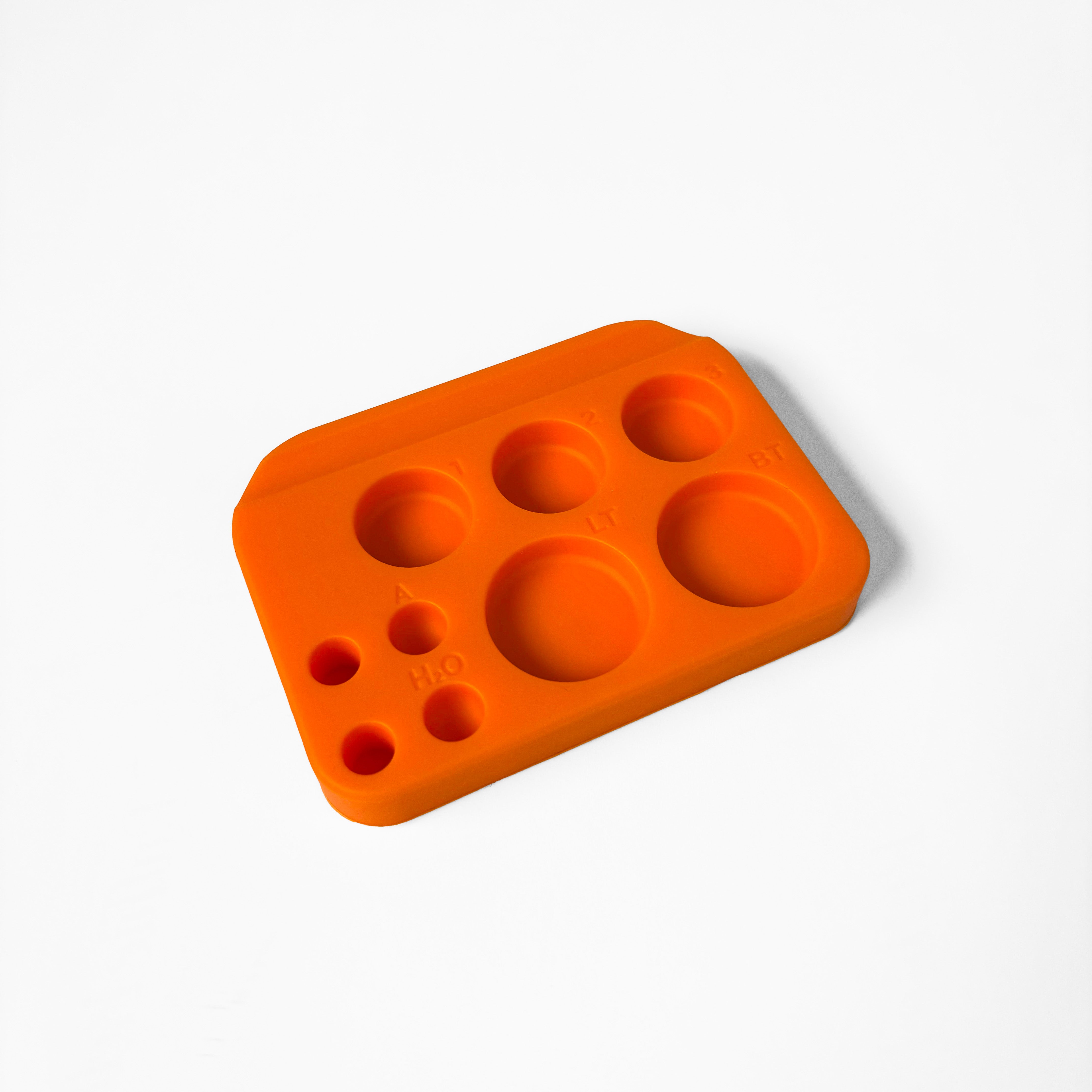 Orange silicone mold with multiple round cavities on a white background